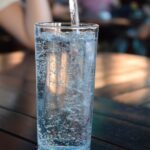 A tall glass of sparkling water or seltzer on a table