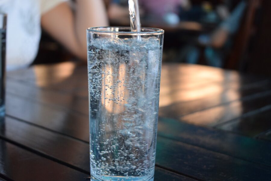 A tall glass of sparkling water or seltzer on a table