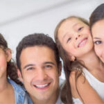 young family of four smile at the family dentist office