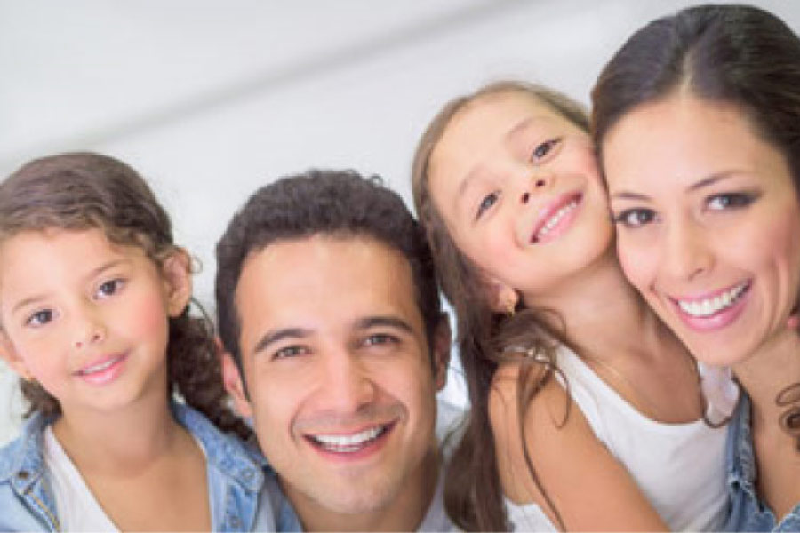 young family of four smile at the family dentist office