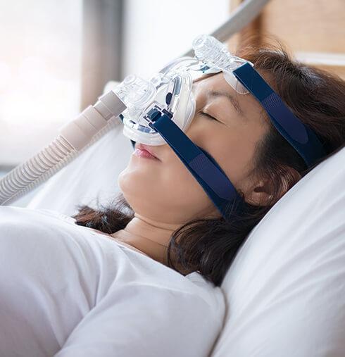 sleeping woman wearing a CPAP mask
