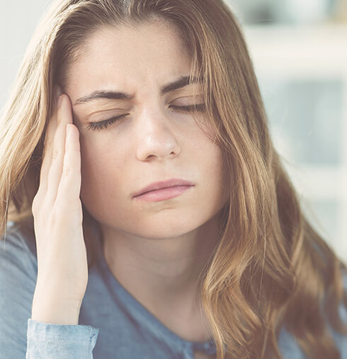 woman holding her jaw in pain