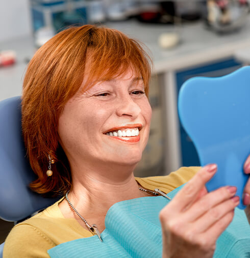 woman at the dentist looking in mirror