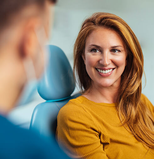 smiling woman talking with her dentist
