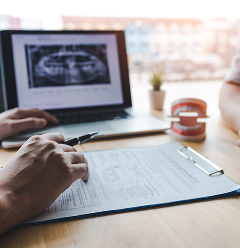 two people discussing dental-related paperwork