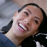 woman in dental chair learning how to maintain smile after cosmetic treatment